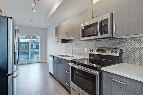 A modern kitchen with a black refrigerator and stainless steel appliances.